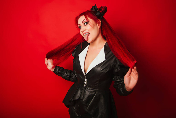 Neformální dívka s rudými vlasy a světlým make-upem. Rocker v černém koženém obleku - Fotografie, Obrázek