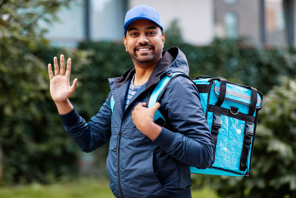 happy smiling indian delivery man with bag in city - Zdjęcie, obraz