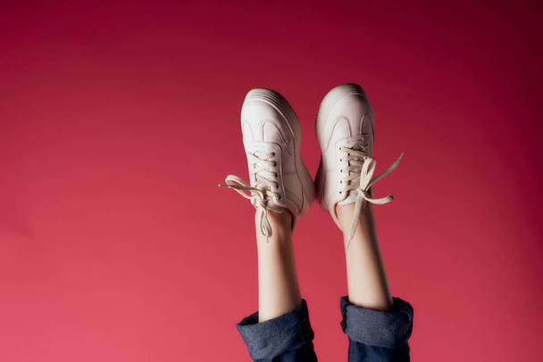 inverted female legs sneakers fashion cropped view - Foto, imagen