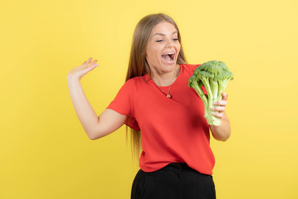 Bild der schönen Frau Modell hält großen grünen Brokkoli. Hochwertiges Foto - Foto, Bild