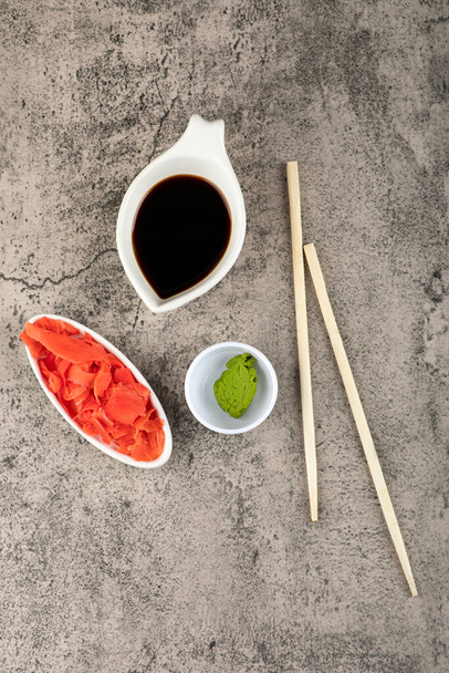 Soy sauce, pickled ginger and wasabi on stone background. High quality photo - Photo, Image