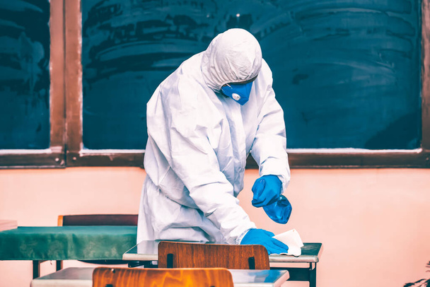 El trabajador pulveriza desinfectante como parte de las medidas preventivas contra la propagación del COVID-19, coronavirus en las escuelas. Preparación para la nueva temporada escolar. - Foto, imagen