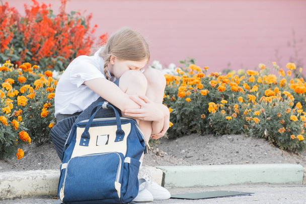Sad desperate young girl suffering from bulling and harassment felling lonely, unhappy desperate and hopeless sitting outdoors. School isolation, abuse and bullying concept - Foto, Bild