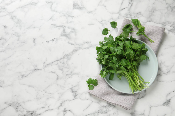 Bunch of fresh aromatic cilantro on white marble table, flat lay. Space for text - Fotografie, Obrázek