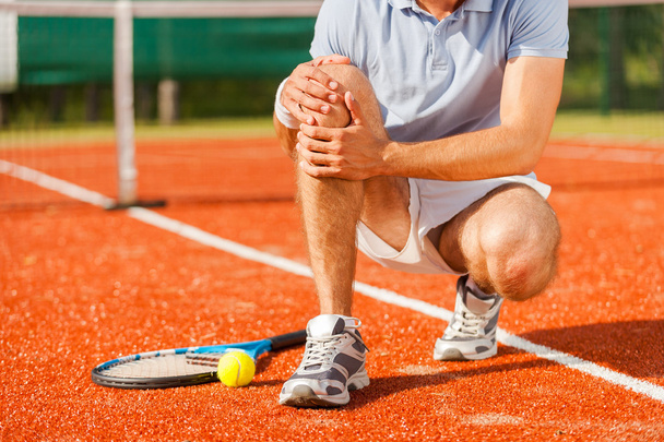 Tennis player touching his knee - Photo, Image