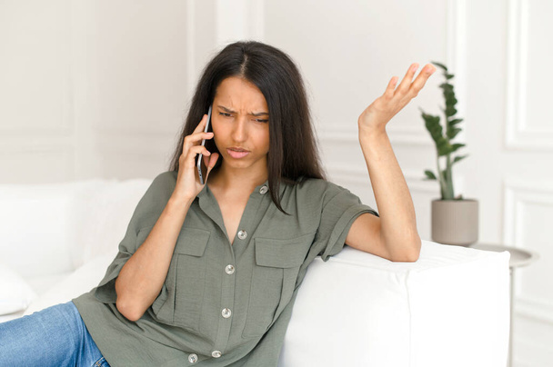 Annoyed mixed-race indian woman talking on smartphone - Foto, Imagem