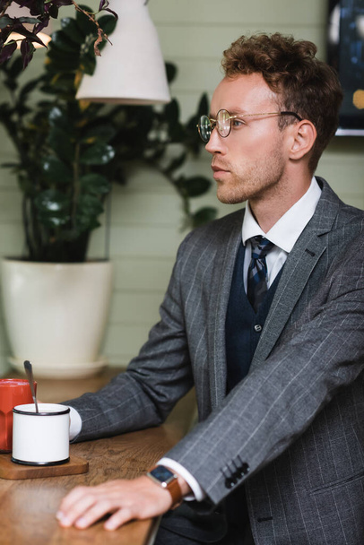 молодий бізнесмен у формальному одязі сидить у кафе
 - Фото, зображення