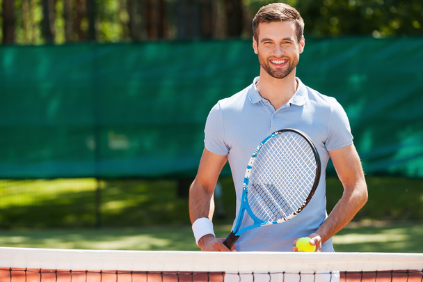 Junger Mann mit Tennisschläger und Ball - Foto, Bild