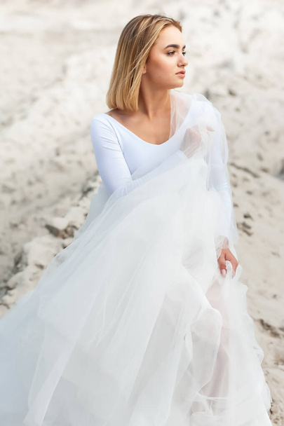 beautiful bride in white dress posing on the beach  - Фото, изображение