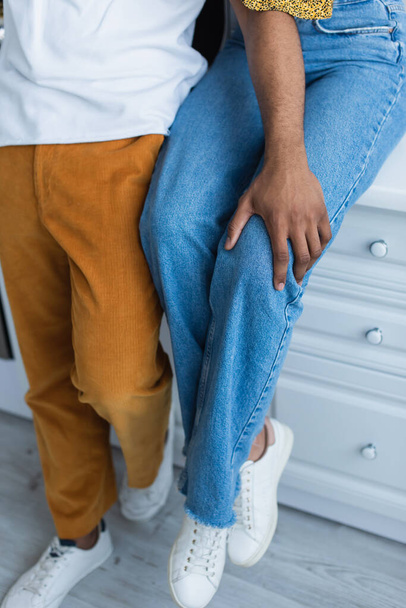 Cropped view of african american man touching knee of girlfriend  - Foto, Imagem