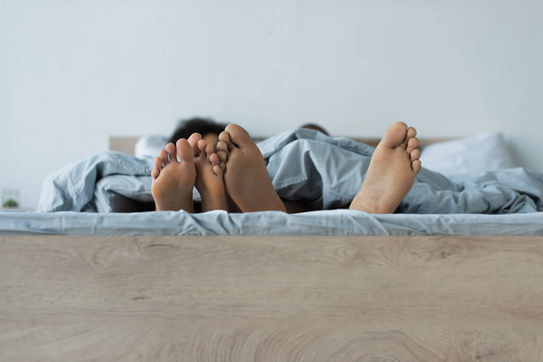 Feet of african american couple on bed  - Фото, зображення