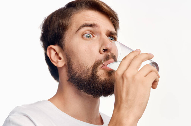 man in white t-shirt drinking water isolated background - Foto, Imagen