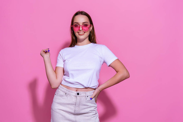Young woman over isolated pink background with glasses - Foto, afbeelding