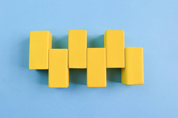 Blocos de cubo de madeira amarelos isolados em um fundo azul - Foto, Imagem