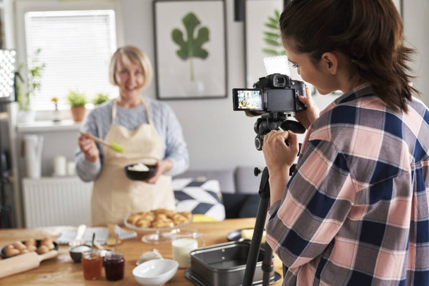 Hija filmando madre mientras cocina - Foto, imagen