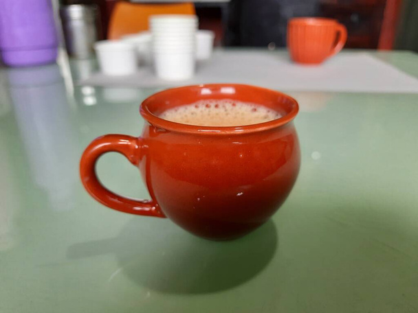 Closeup of single red or Brown color clay, sand coffee cup on a table - Photo, Image