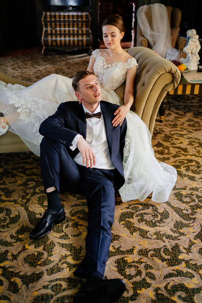 bride and groom on the couch. rent of clothes and hall for the holiday. - Фото, зображення