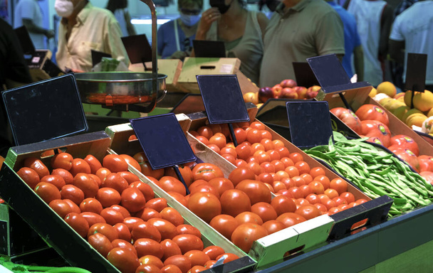 Az emberek gyümölcsöt és zöldséget vásárolnak a "Mercado Central" -ban Zaragozában. Üres táblajelek az árak testreszabásához. Szelektív fókusz. Helyi piaci koncepció. - Fotó, kép