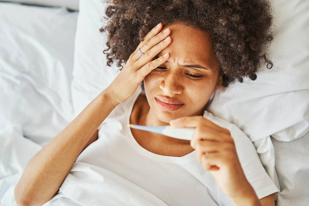 Malade jeune femme brune couchée au lit - Photo, image