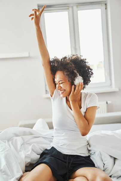 Joyous dame luisteren naar haar favoriete muziek in de ochtend - Foto, afbeelding