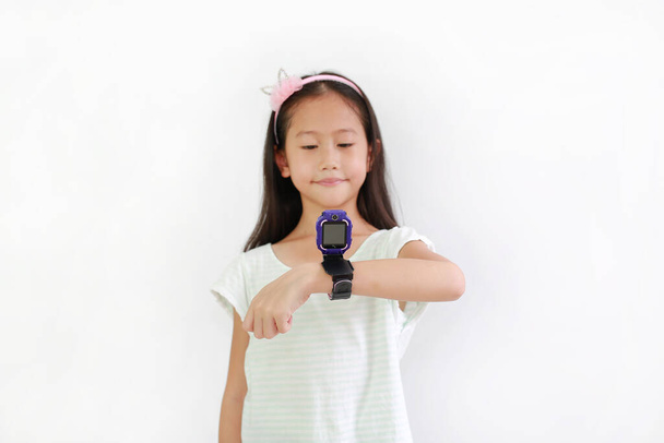 Asian little girl child using smart watch video camera against white background. Focus at smart watch at his hands - Fotoğraf, Görsel