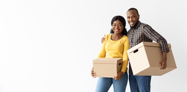 Día de mudanza. Retrato de cónyuges afroamericanos felices con cajas de cartón - Foto, Imagen