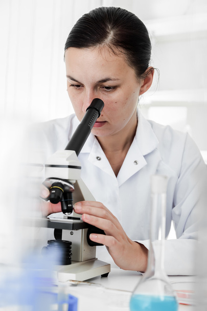 Scientist using a microscope in a laboratory - Фото, изображение