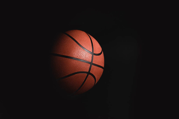 Basketball auf schwarzem Hintergrund im Dunkeln mit Werbefläche - Foto, Bild