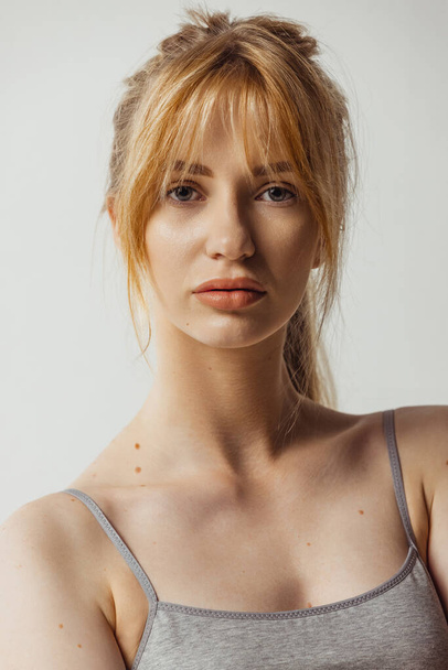 Close-up portrait of young beautiful tanned woman without makeup isolated over gray studio background. Natural beauty concept. - Valokuva, kuva