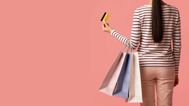 Sales And Discounts. Woman Holding Shopping Bags And Credit Card, Back View - Foto, imagen