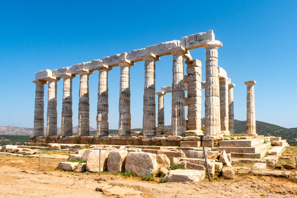 L'antico tempio greco di Poseidone a Capo Sounion, colonne doriche e rovine sulla collina con sfondo di cielo blu cristallino. - Foto, immagini