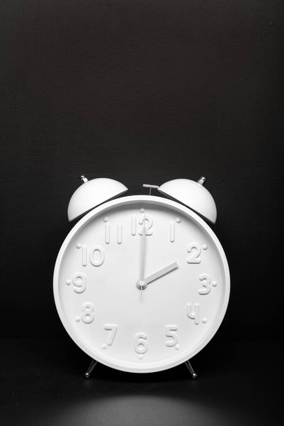 Daylight saving time concept. White Retro clock isolated on black background. Copy space - Photo, Image