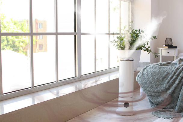 Современный увлажнитель воздуха возле окна в спальне - Фото, изображение