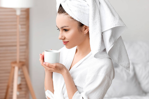 若い女性は寝室でコーヒーを飲む - 写真・画像