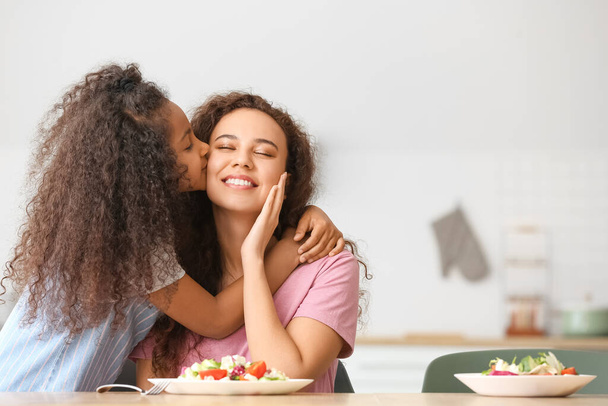 アフリカ系アメリカ人の女の子接吻彼女の母親でキッチン - 写真・画像