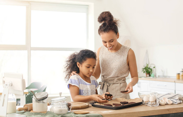 Menina afro-americana e sua mãe preparando biscoitos na cozinha - Foto, Imagem