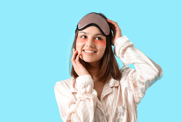 Young woman with under-eye patches on color background - 写真・画像