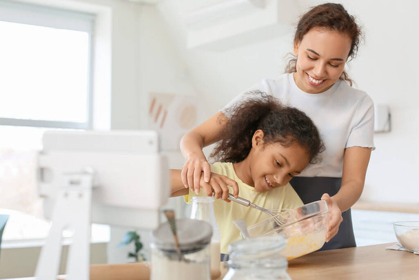 アフリカ系アメリカ人の少女と彼女の母親の台所で調理 - 写真・画像