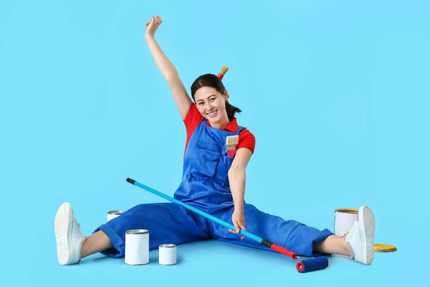 Female painter with roller brush on color background - Photo, Image