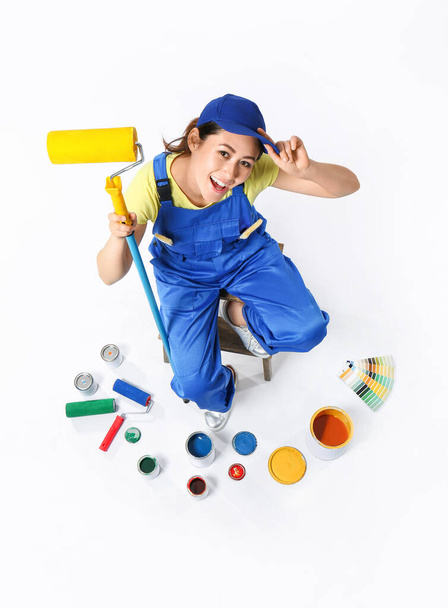 Female decorator with painter's tools on white background - Fotó, kép