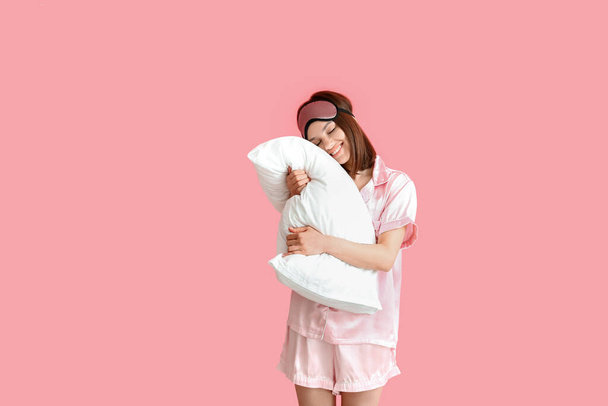 Nuori nainen halaus tyyny väri tausta - Valokuva, kuva