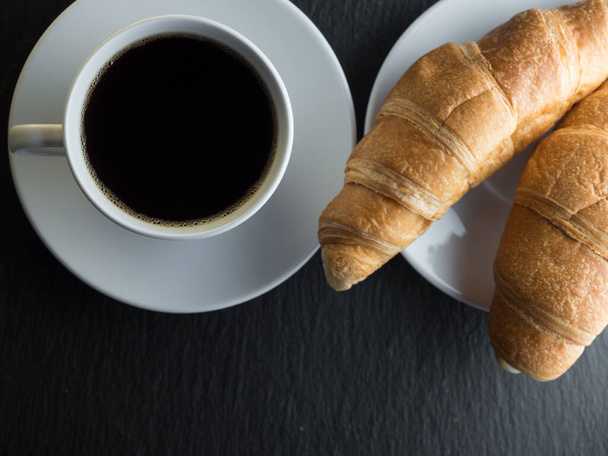 Cup of coffe and croissants on black slate background - Foto, immagini