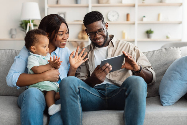 Famille noire ayant vidéocall en utilisant une tablette agitant les mains - Photo, image