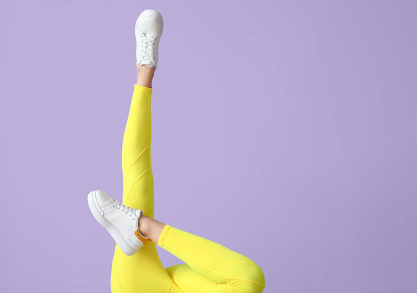 Lábak sportos fiatal nő leggings színes háttér - Fotó, kép