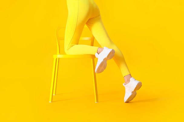 Jeune femme sportive avec chaise sur fond de couleur - Photo, image
