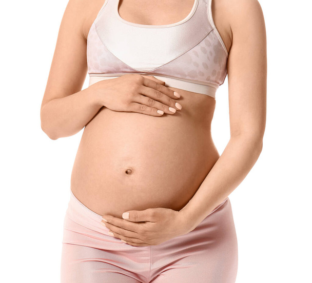 Νεαρή έγκυος γυναίκα σε λευκό φόντο - Φωτογραφία, εικόνα