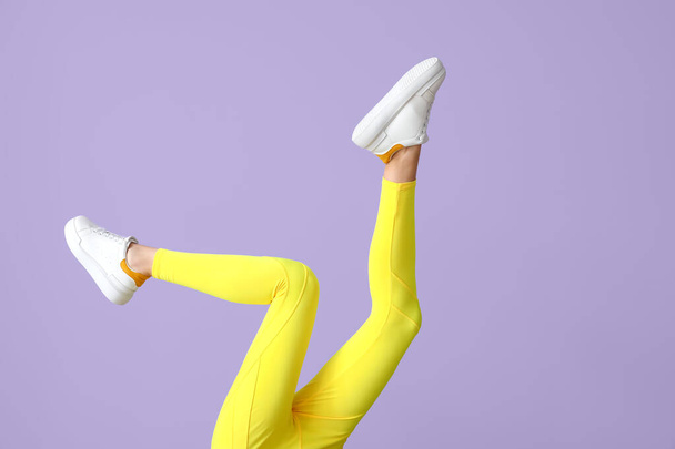 Legs of sporty young woman in leggings on color background - Foto, Bild