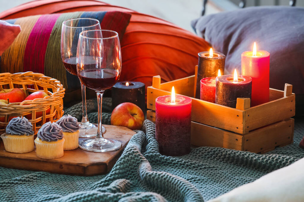 Composition avec bougies allumées, verres et nourriture sur canapé - Photo, image