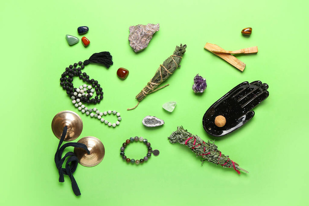 Состав с драгоценными камнями, караталами и травами для очистки ауры на цветном фоне - Фото, изображение