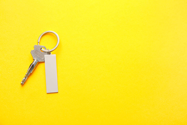 Κλειδί με κομψό μπρελόκ στο φόντο χρώμα - Φωτογραφία, εικόνα